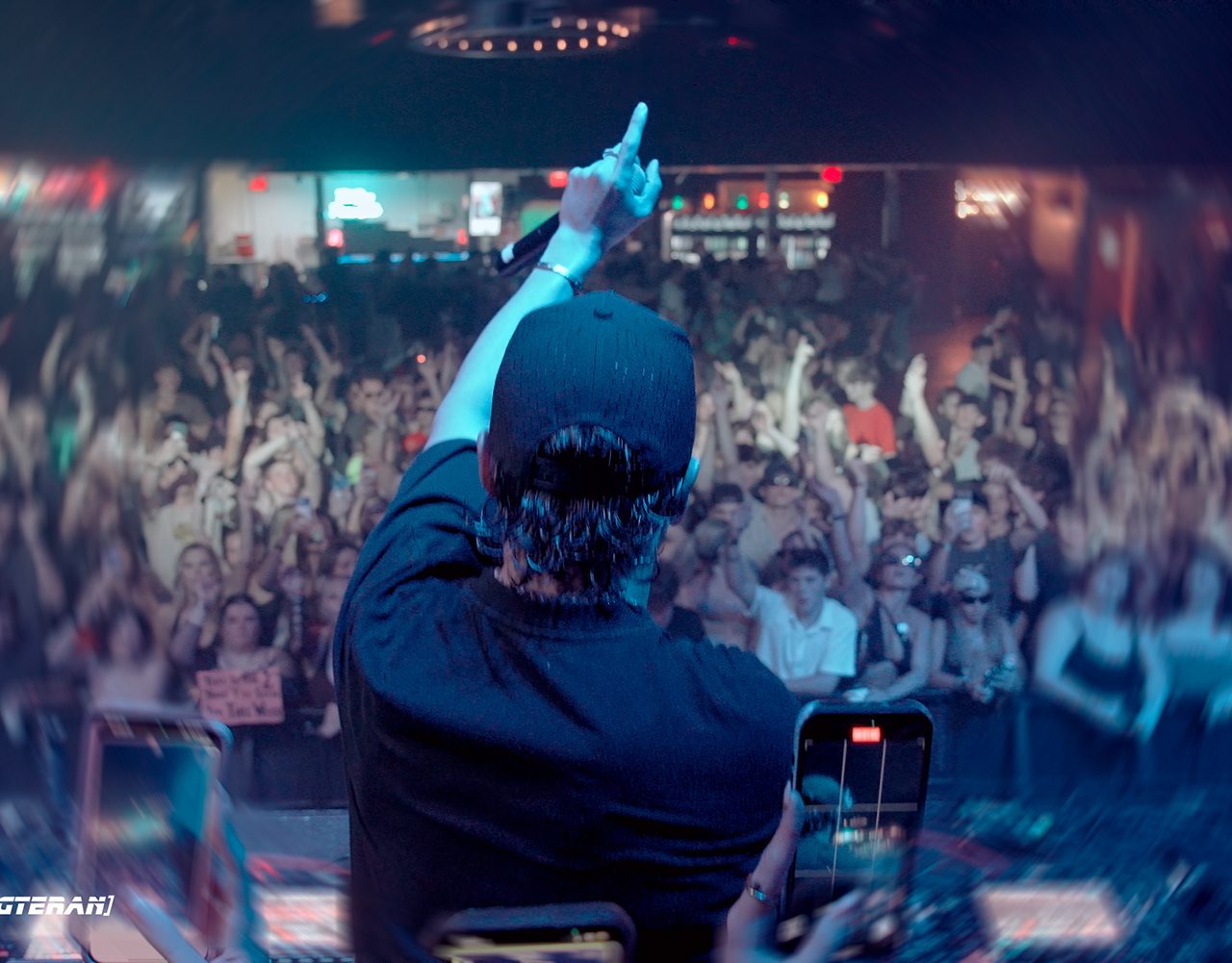 ACRAZE pointing out at a packed crowd from behind the DJ booth
