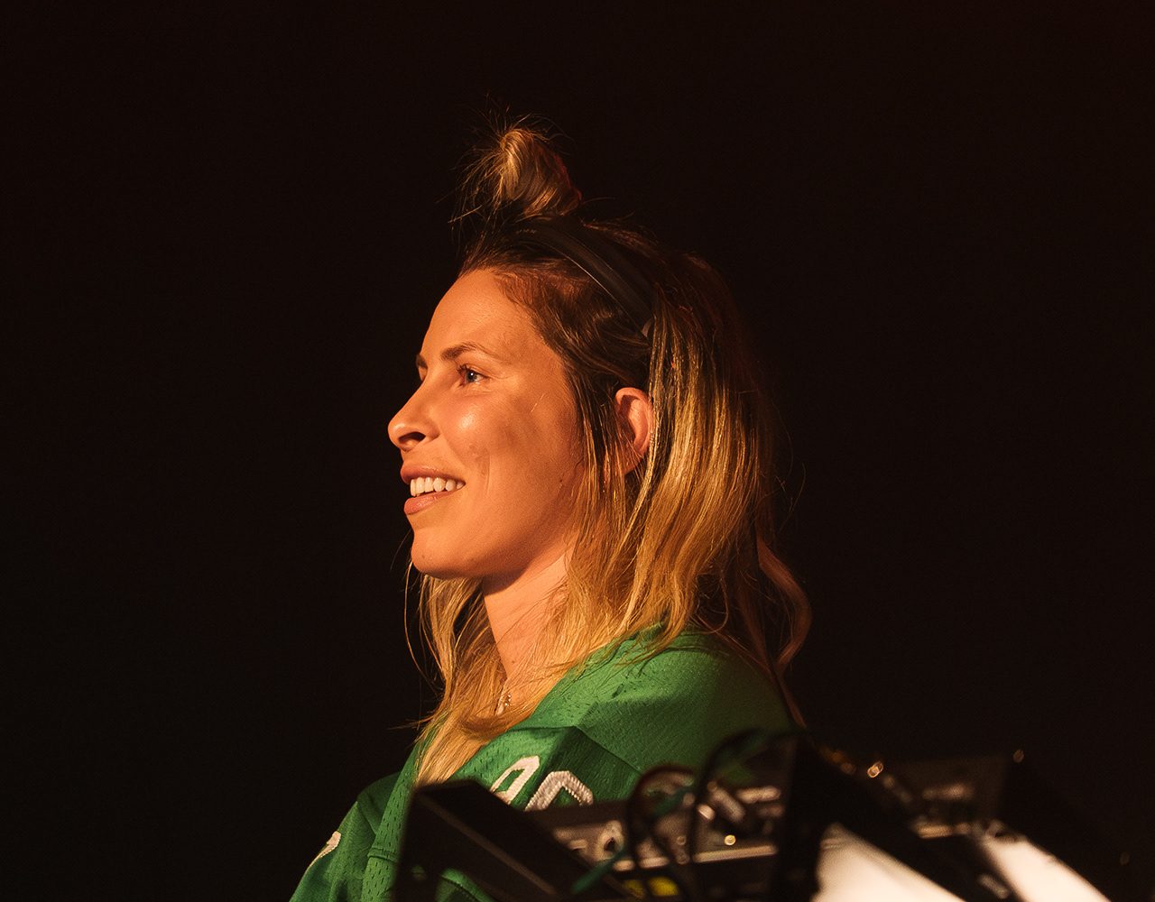 Blond:ish smiling in profile behind the decks