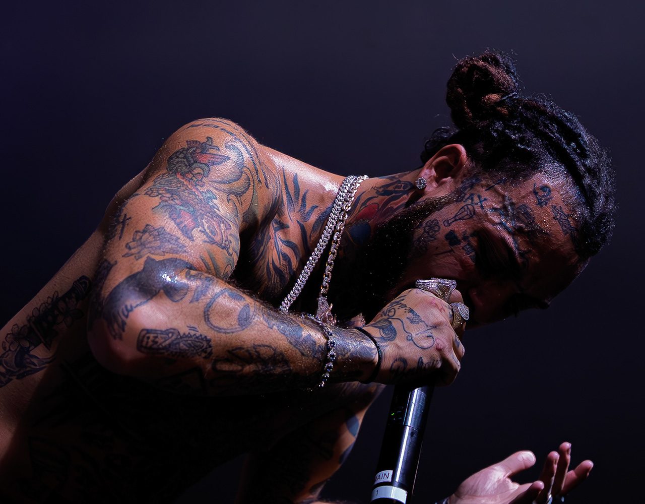 Lil Skies performing shirtless, head down over the microphone