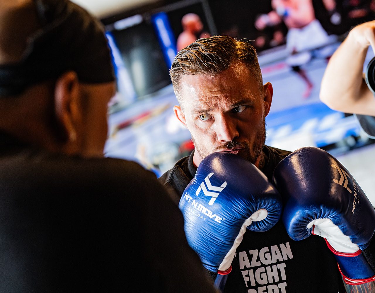 Murat Kazgan holding his guard in blue boxing gloves during a training session